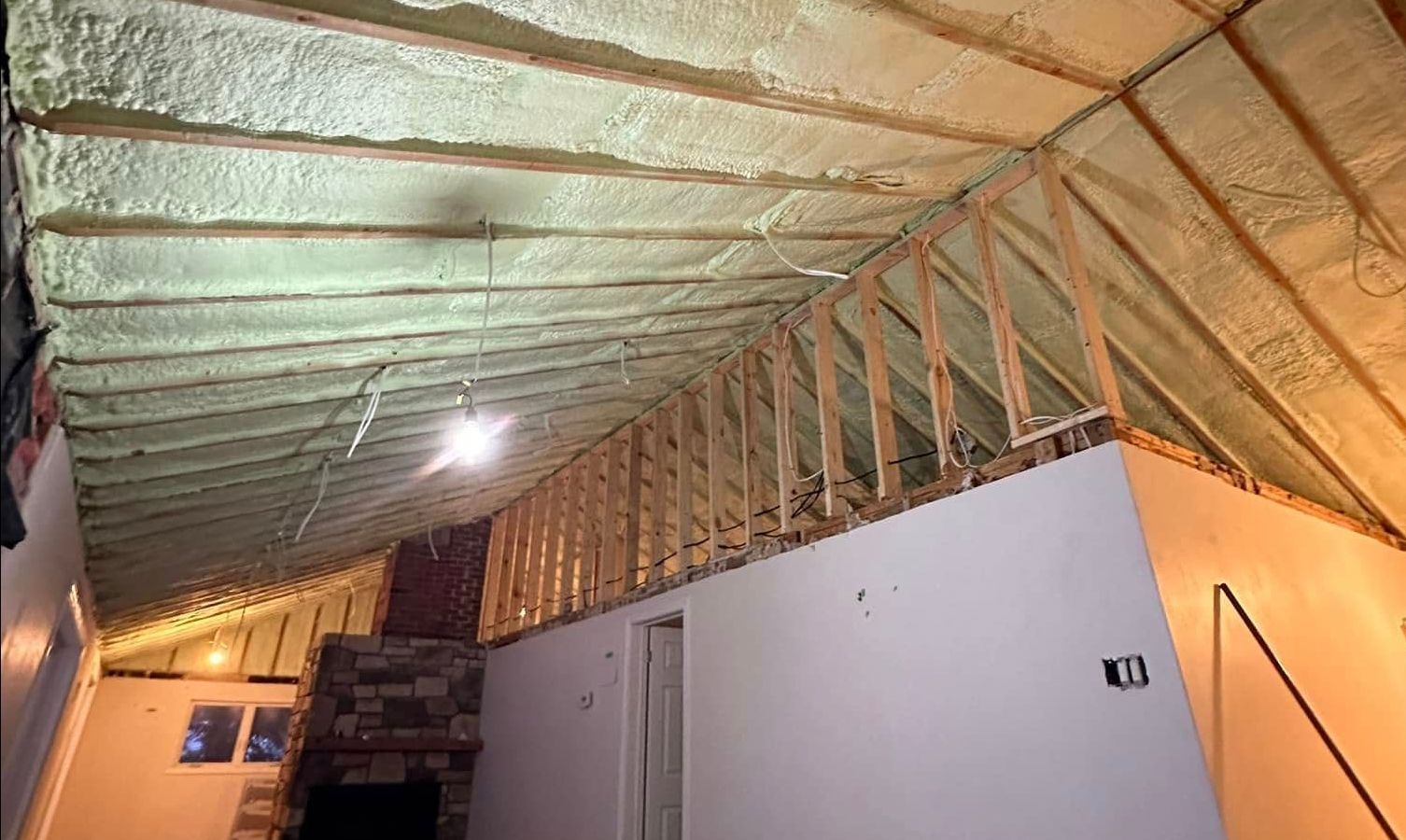 A room with a ceiling that is being insulated with spray foam.