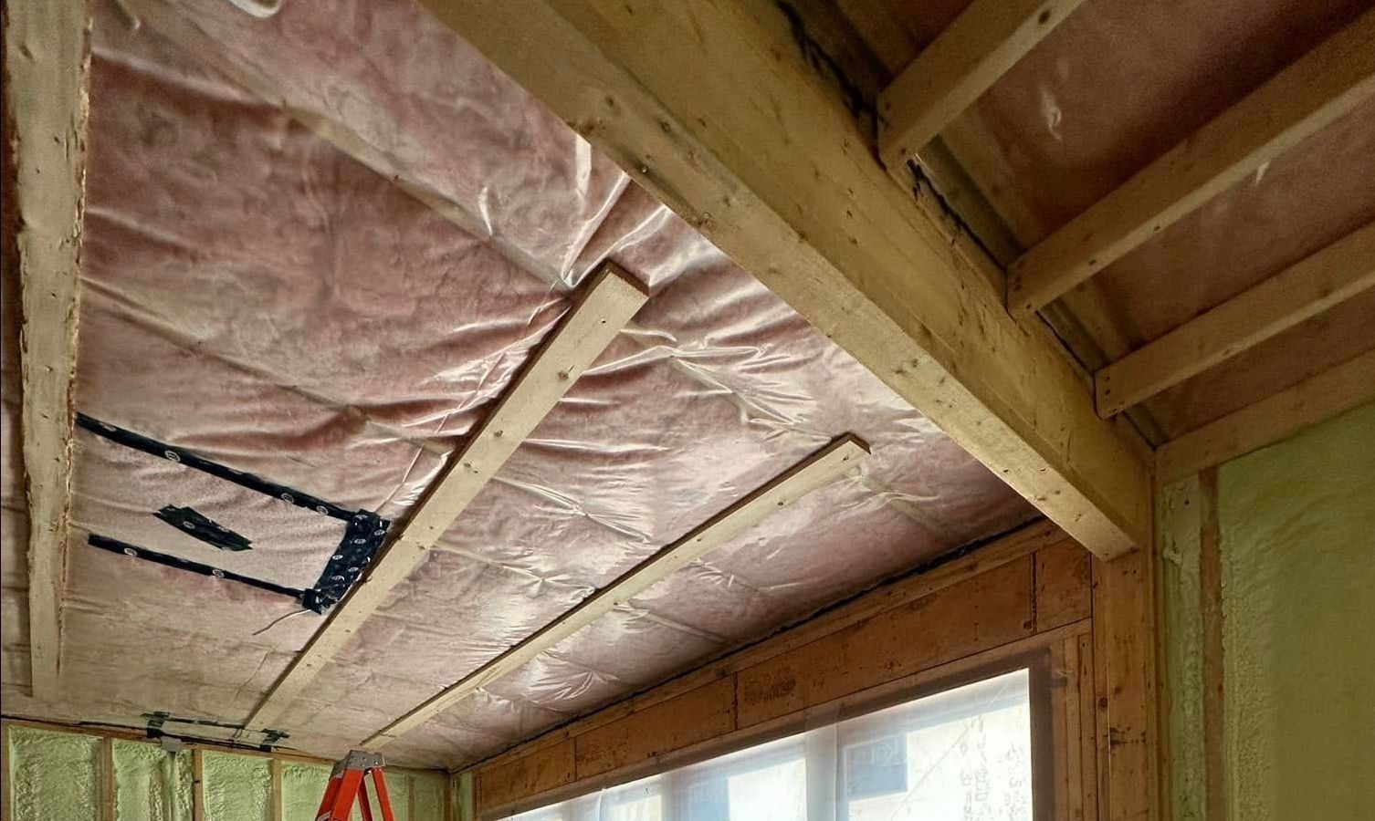 A room with a lot of insulation on the ceiling and a window.