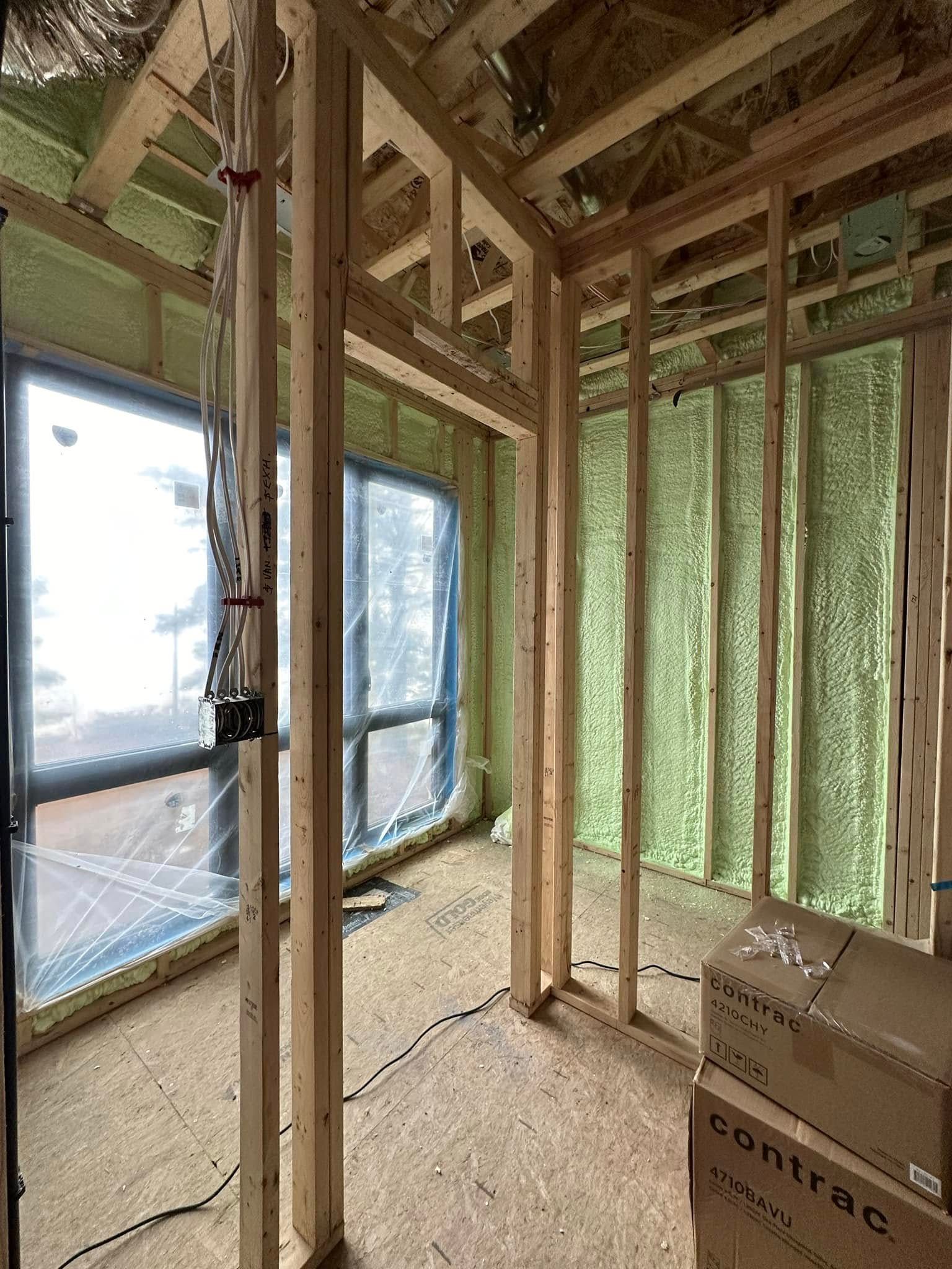A room in a house under construction with boxes on the floor.