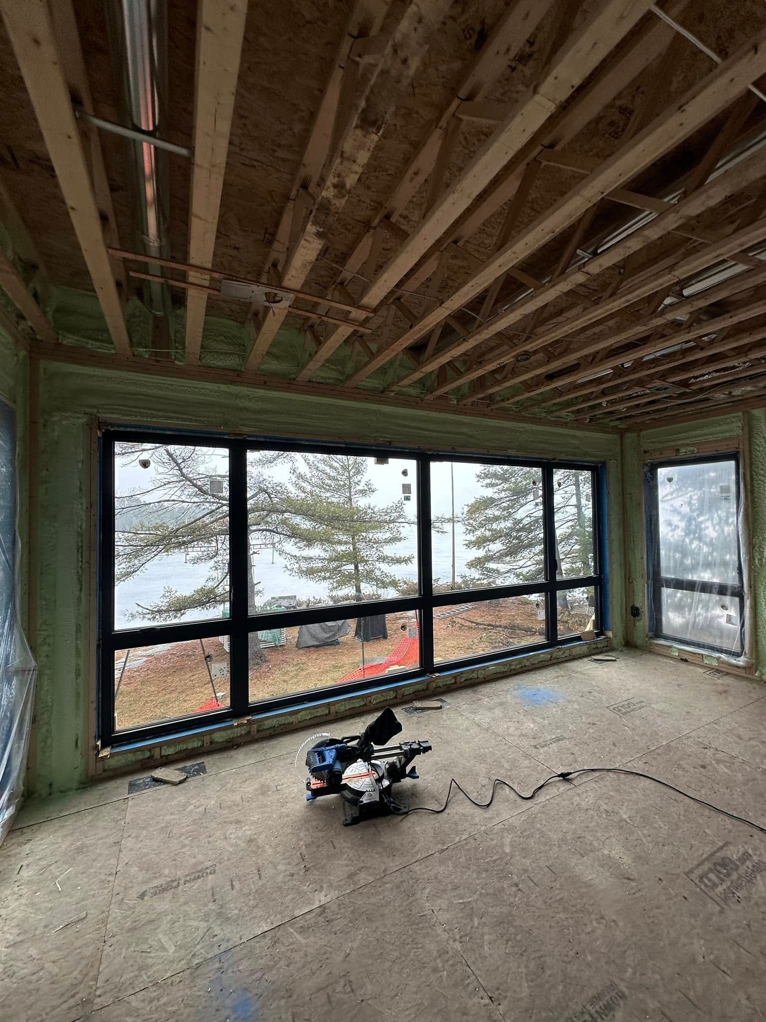 A room in a house under construction with a lot of windows.