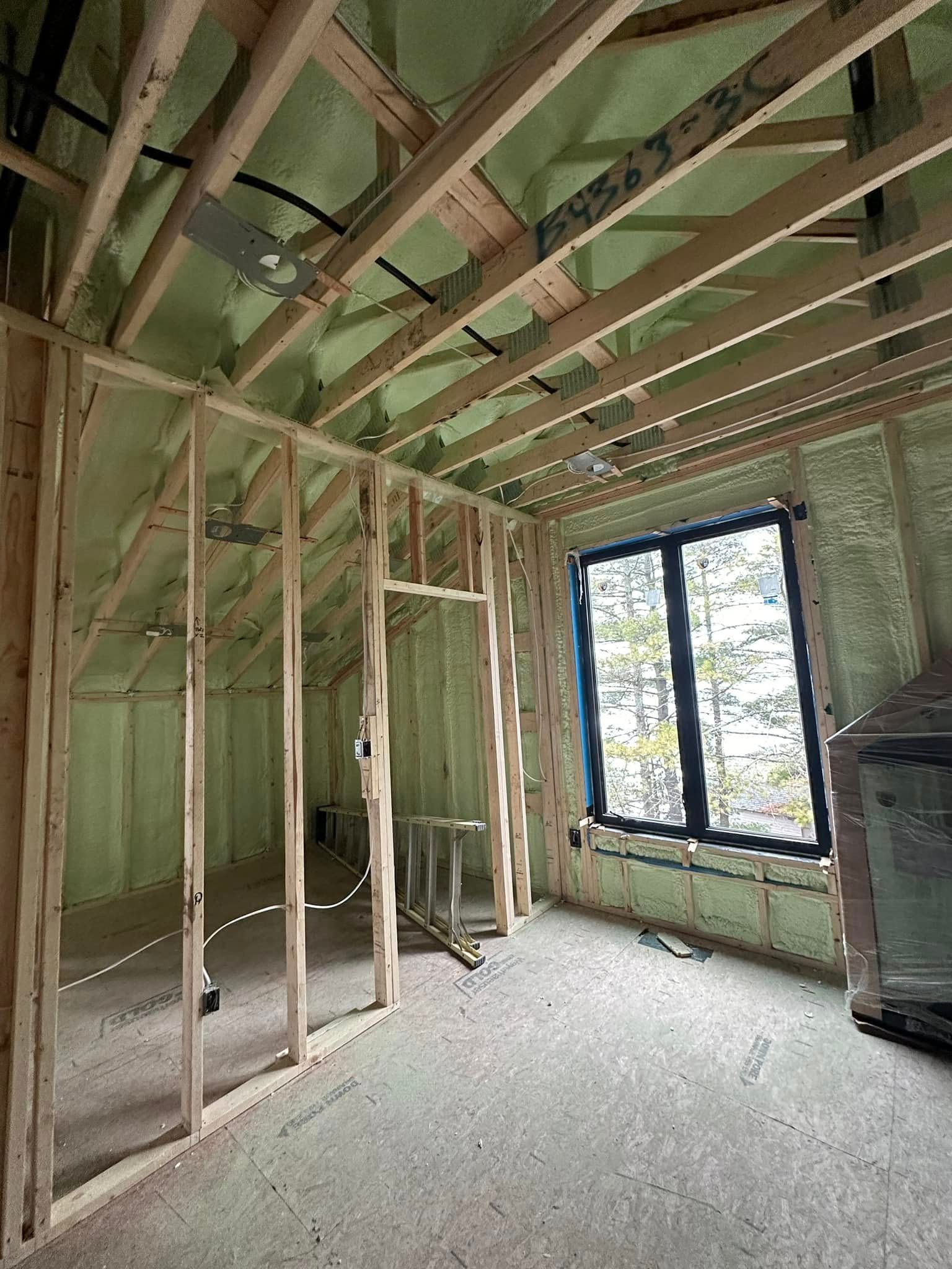 A room in a house under construction with a lot of wooden beams.