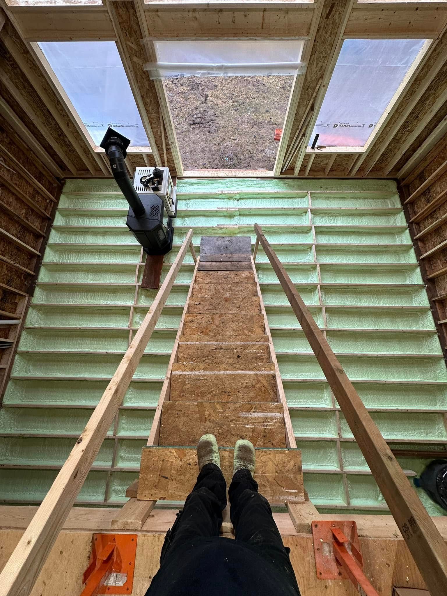 A person is standing on a set of stairs in a building under construction.