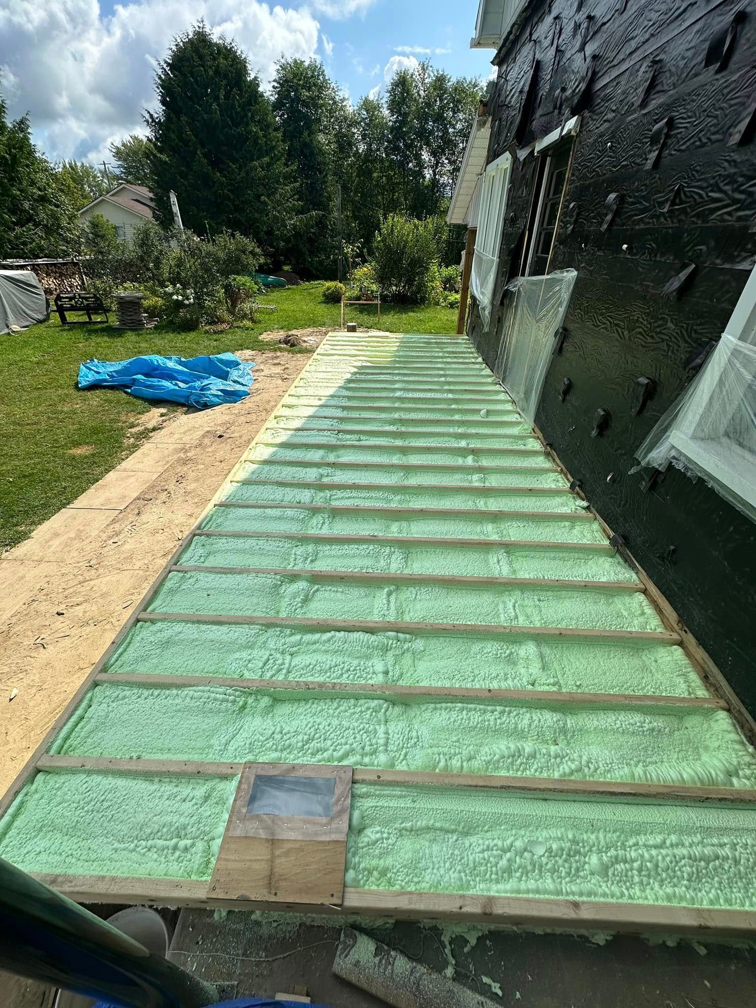 A wooden deck is being built in the backyard of a house.