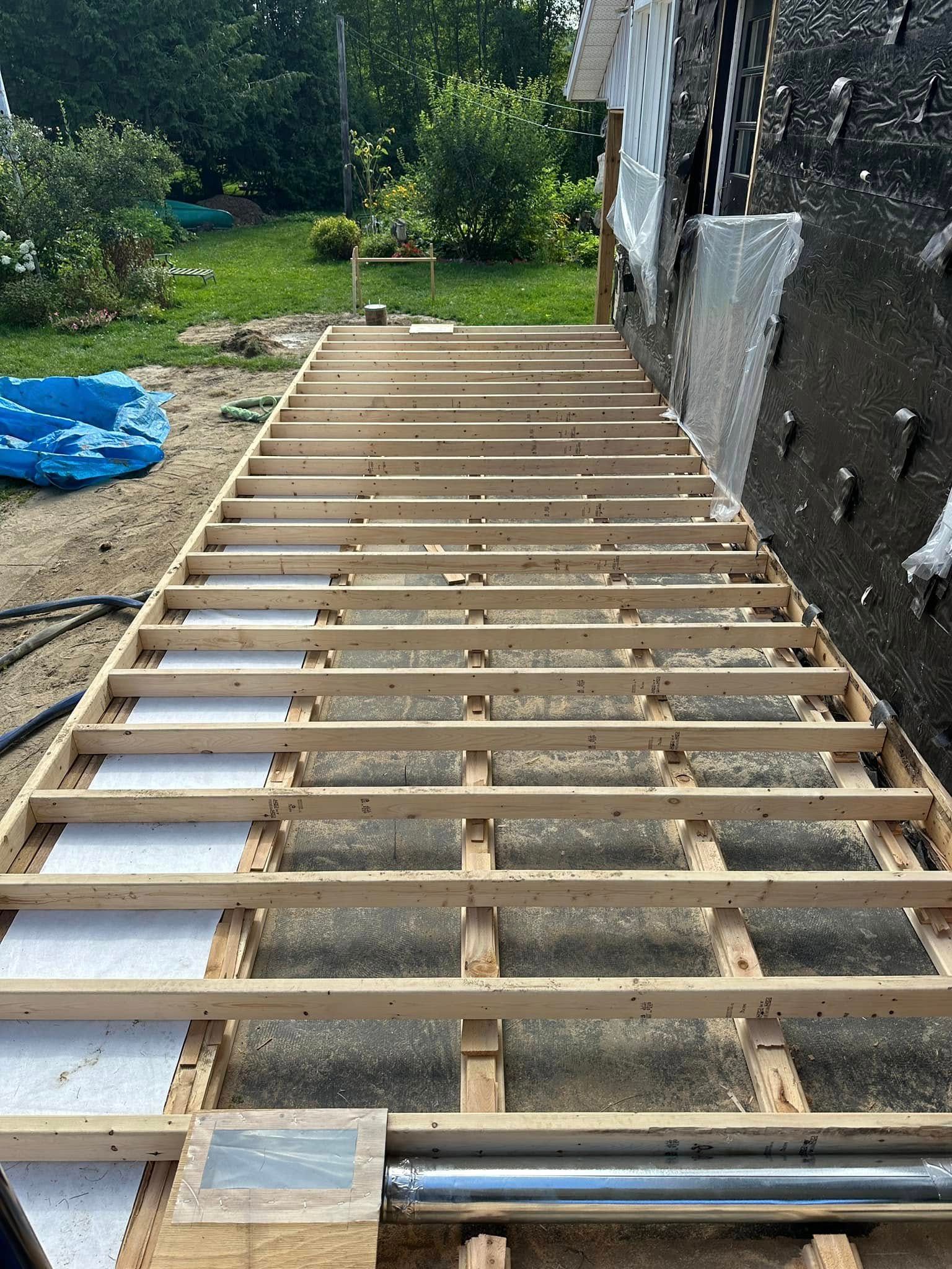 A wooden floor is being built on top of a dirt field.