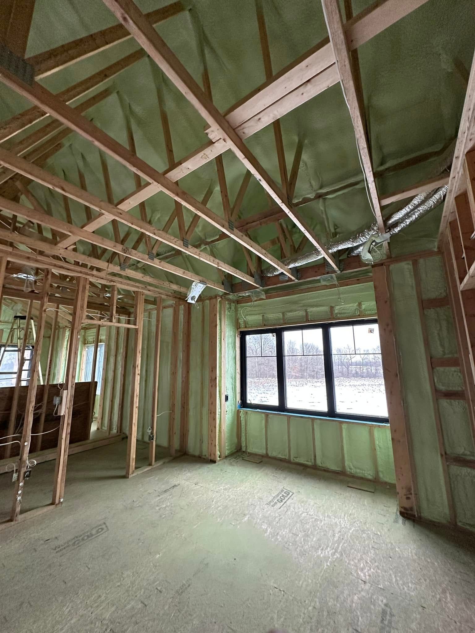 A room in a house under construction with a lot of insulation on the walls and ceiling.