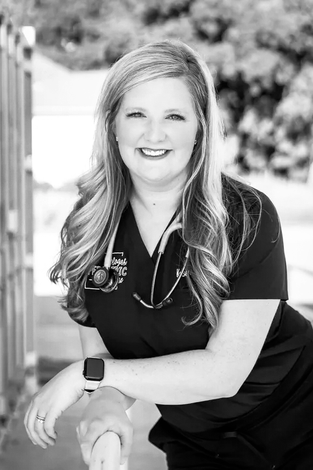 A black and white photo of a nurse with a stethoscope around her neck.