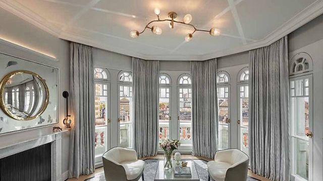 A living room with a lot of windows and a fireplace.