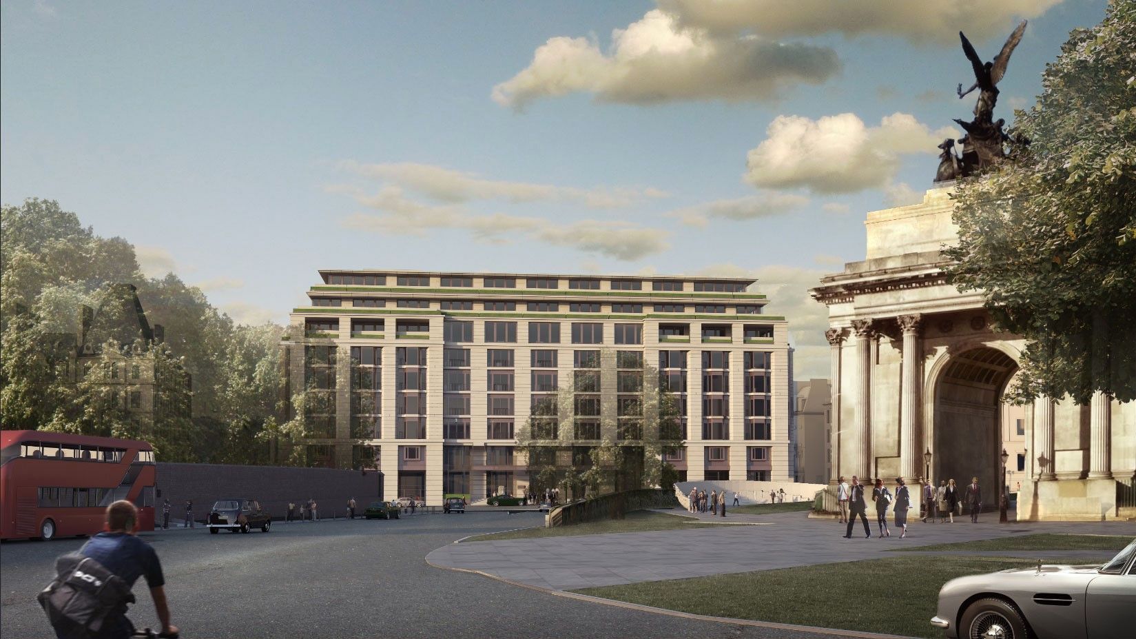 A man is riding a bike in front of a large building