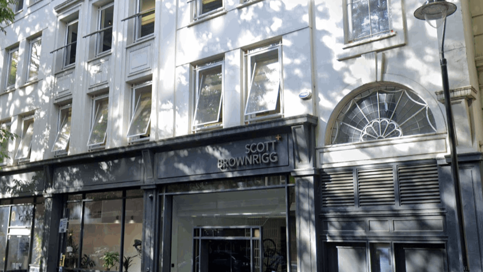 A large white building with a lot of windows and a sign that says scott browning on it.