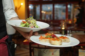 Restaurant staff bring out meals.