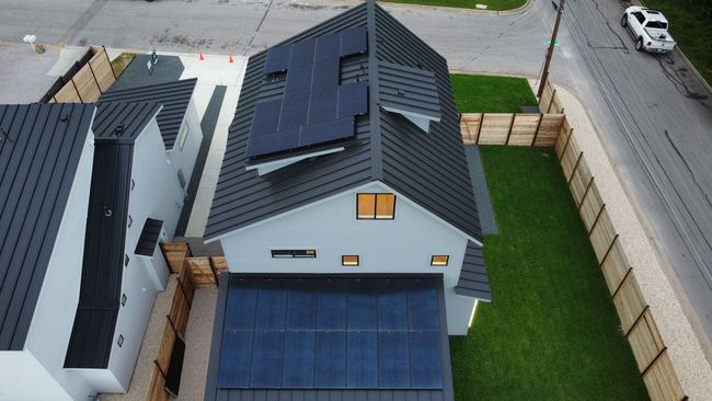 An aerial view of a house with solar panels on the roof