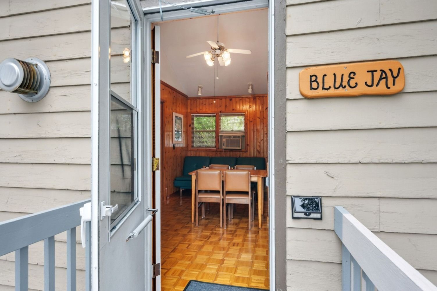 Exterior view of the Blue Jay cabin doorway open to the interior dining area.