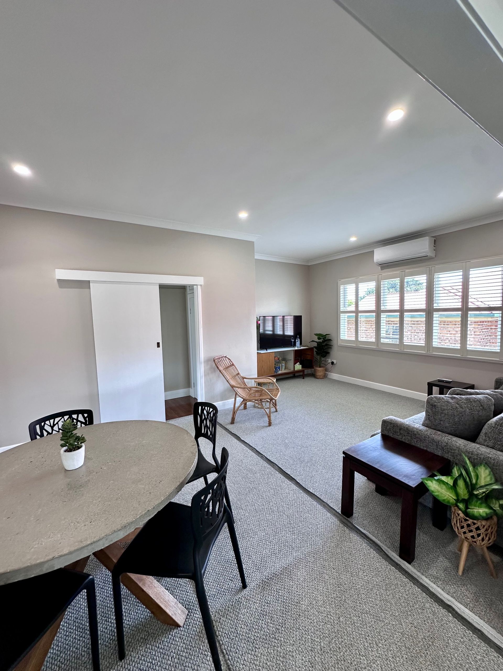 A living room with a couch , table , chairs and a television.