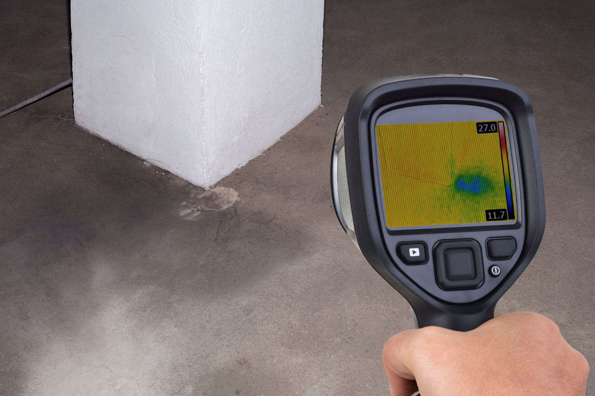 A person is holding a thermal camera in their hand.