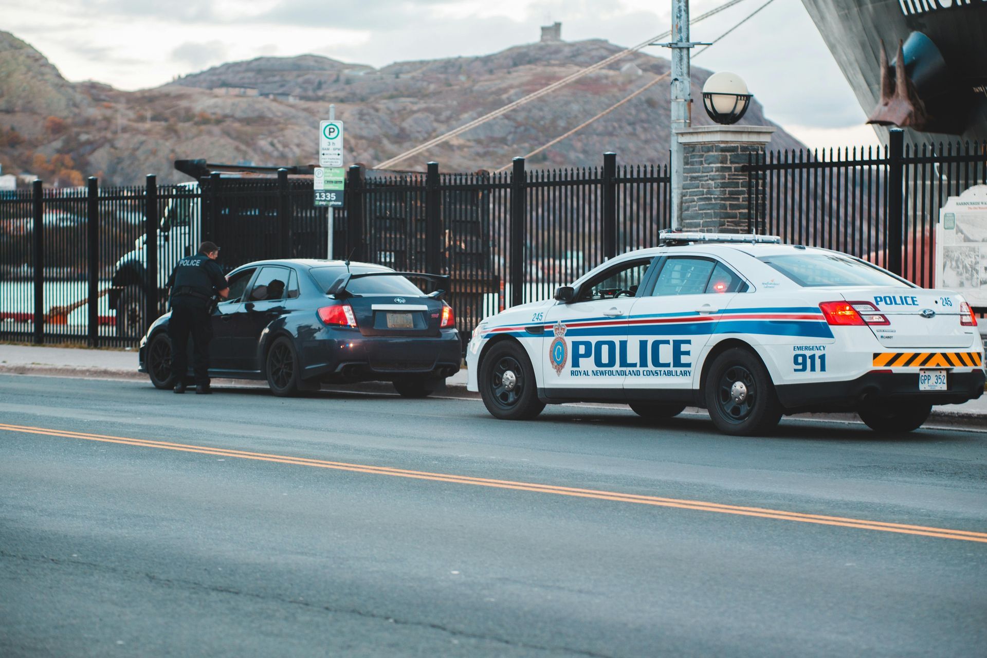 A police car is stopping a car on the side of the road.