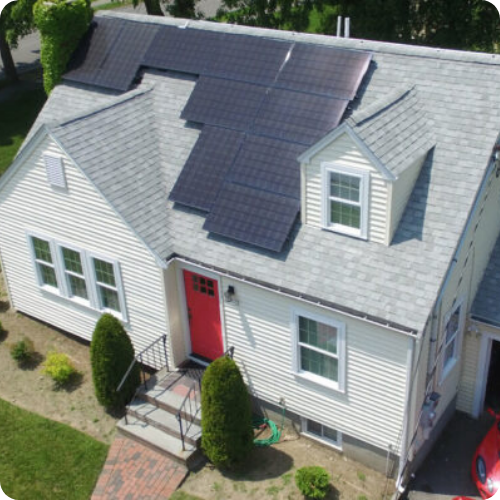 An aerial view of a house with solar panels on the roof