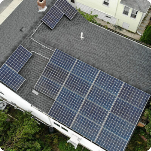 An aerial view of a house with solar panels on the roof.