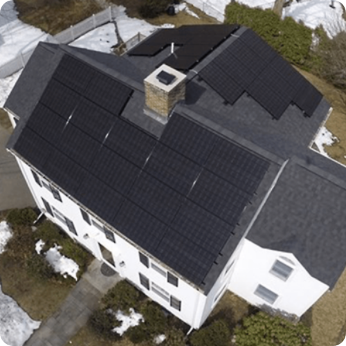 An aerial view of a house with solar panels on the roof