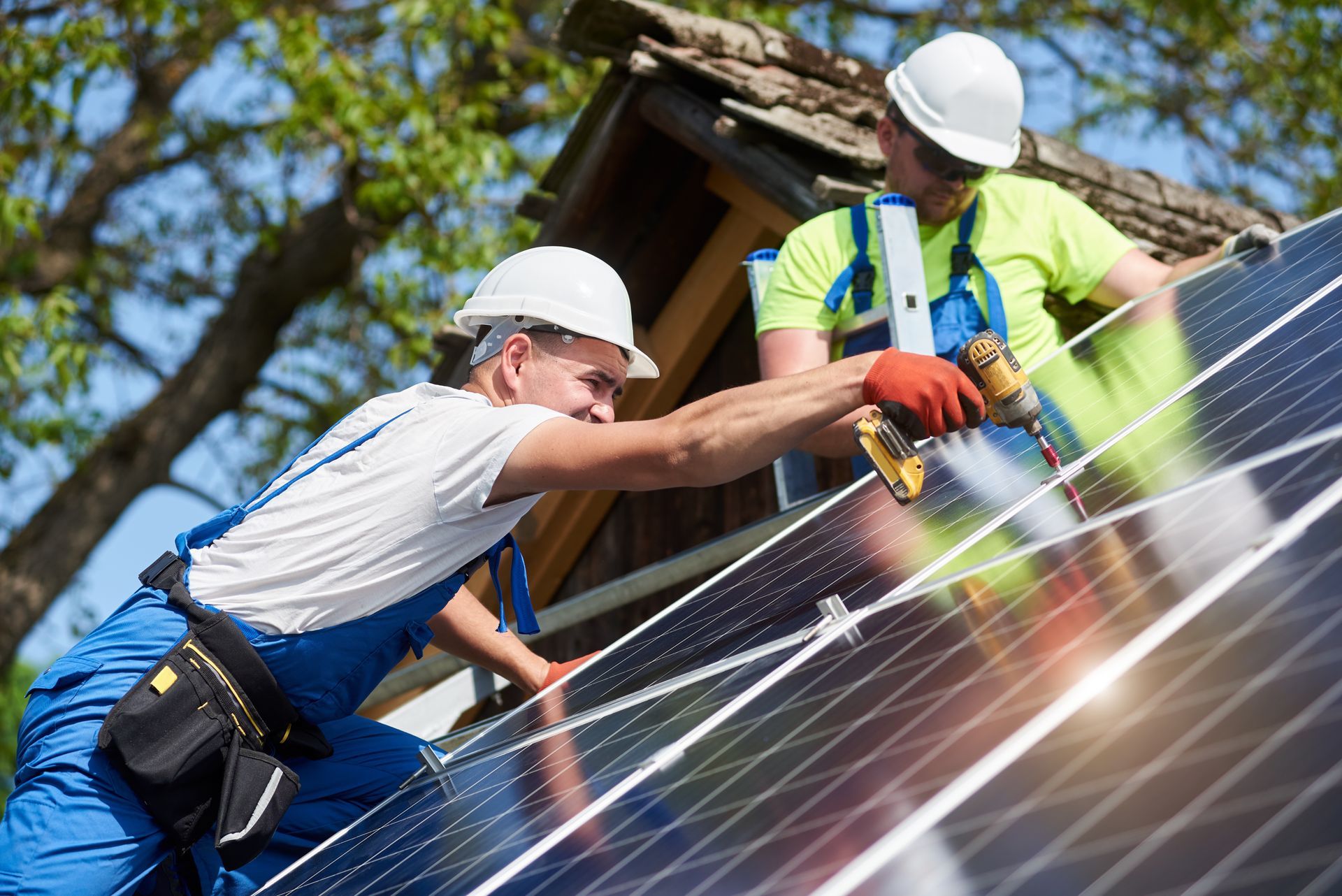 Contractors in protective gear installing solar panels.