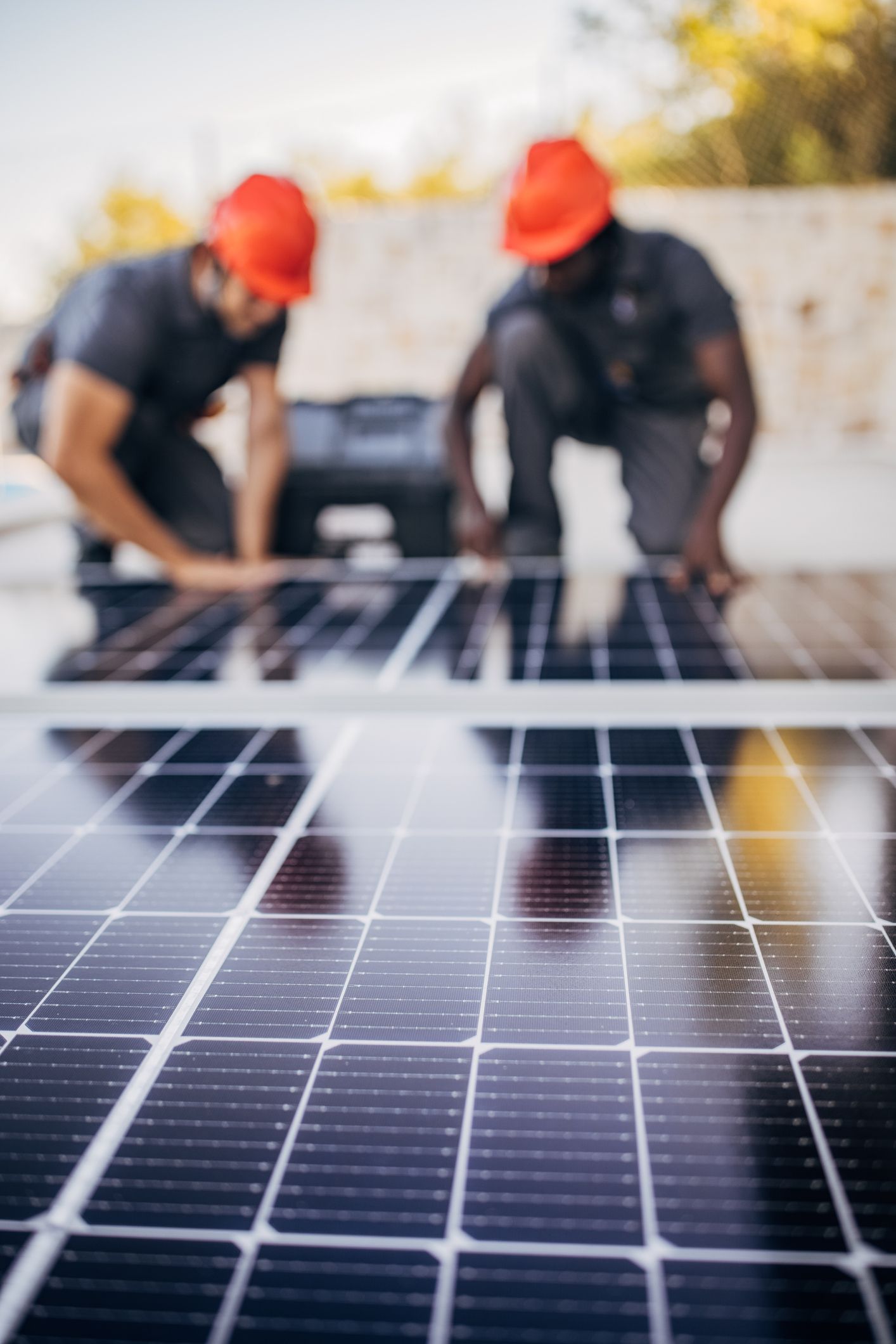 Male engineers with protective helmets preparing for installing solar panels.