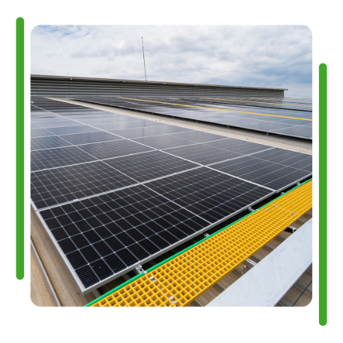 There are many solar panels on the roof of a building.