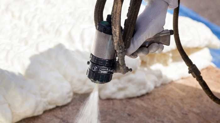 A cup of coffee , cinnamon sticks , and nuts on a window sill.