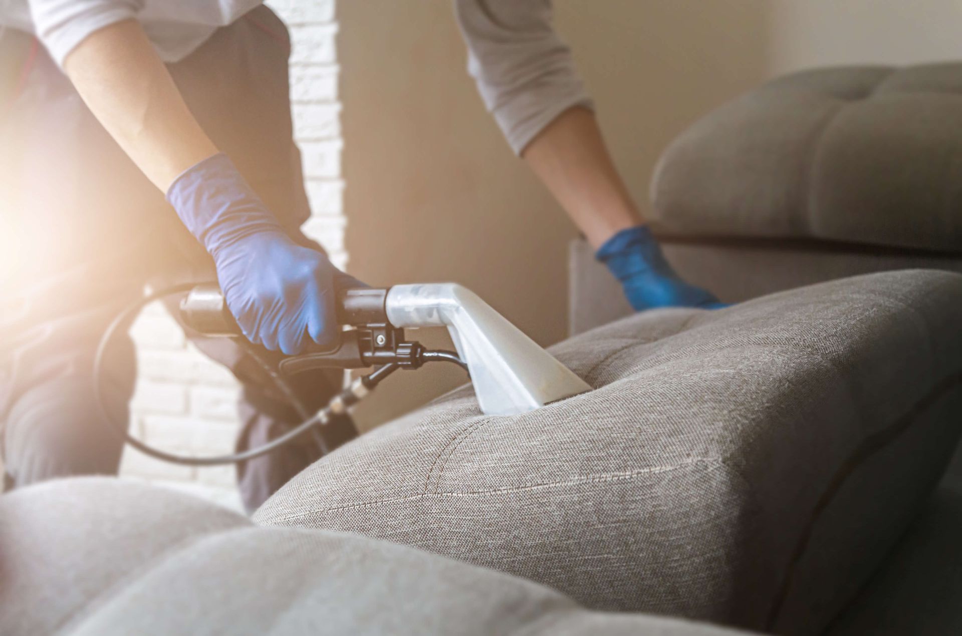 A worker cleaning sofa in living room
