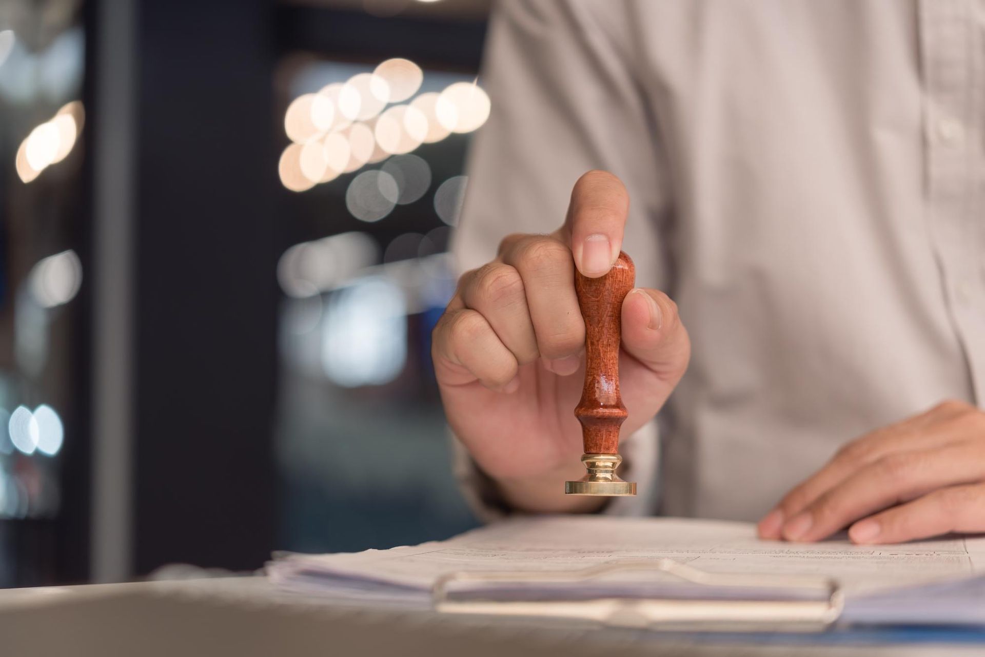 Person stamping a document with a wooden stamp