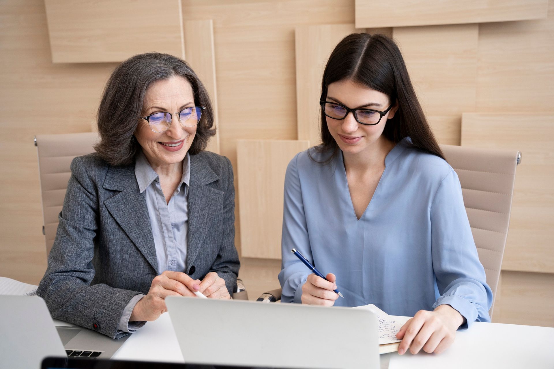 Two women, looking at a laptop together