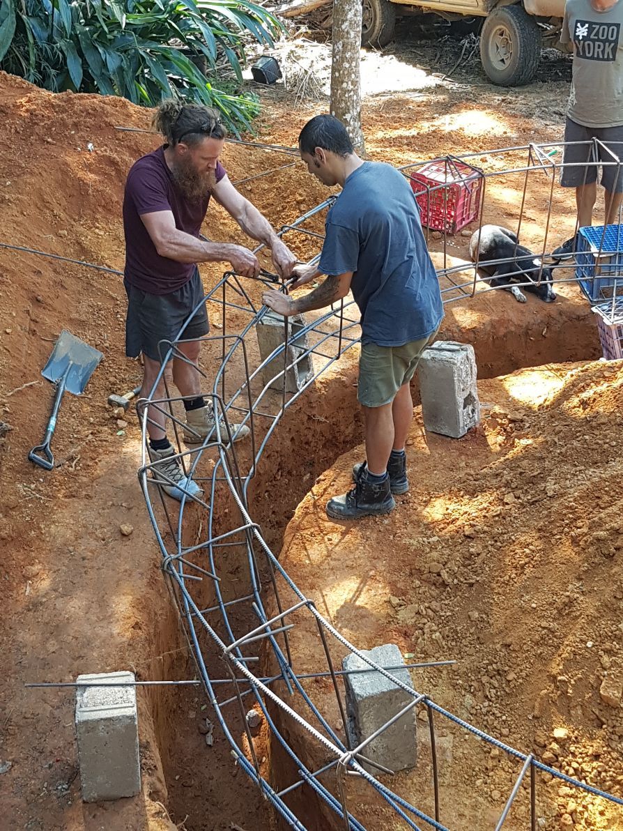 A Man Is Pouring Concrete on A Construction Site — Bunker FNQ in Kuranda, QLD