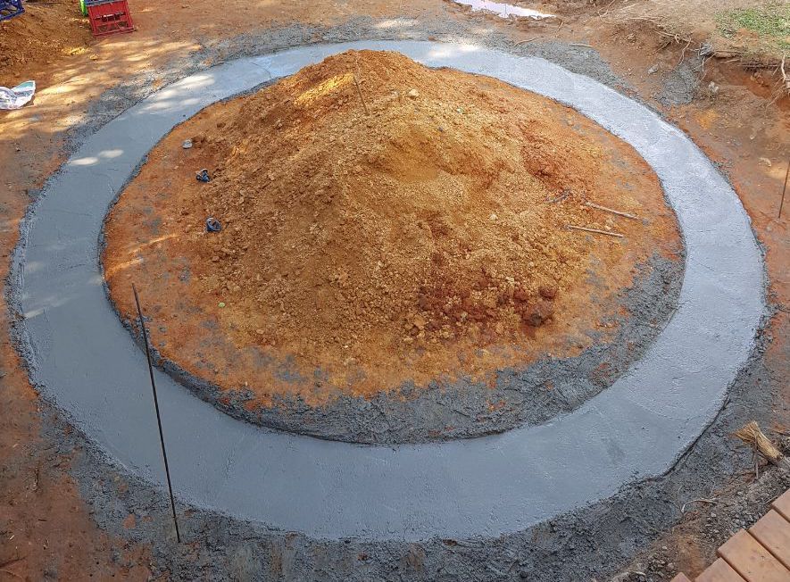A Person Wearing Yellow Boots Is Using a Broom on A Concrete Floor — Bunker FNQ in Kuranda, QLD
