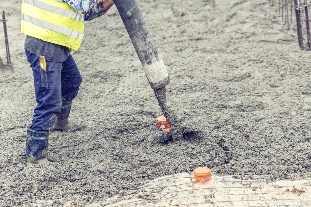 A Construction Worker Is Pouring Concrete Into the Ground — Bunker FNQ in Kuranda, QLD