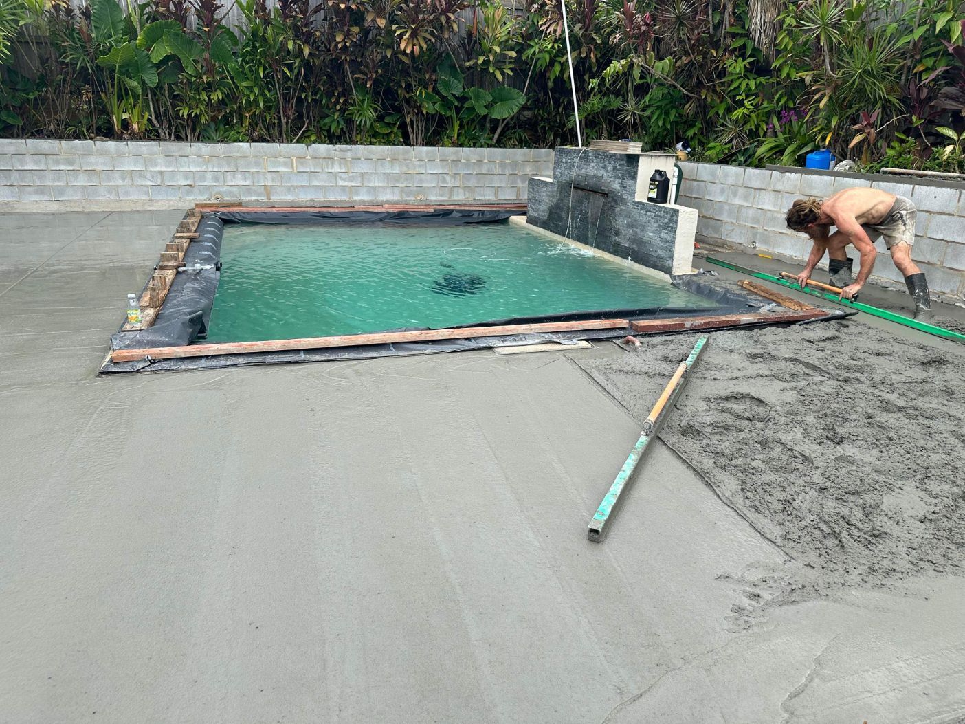 A Man Is Standing in The Dirt with A Shovel — Bunker FNQ in Kuranda, QLD