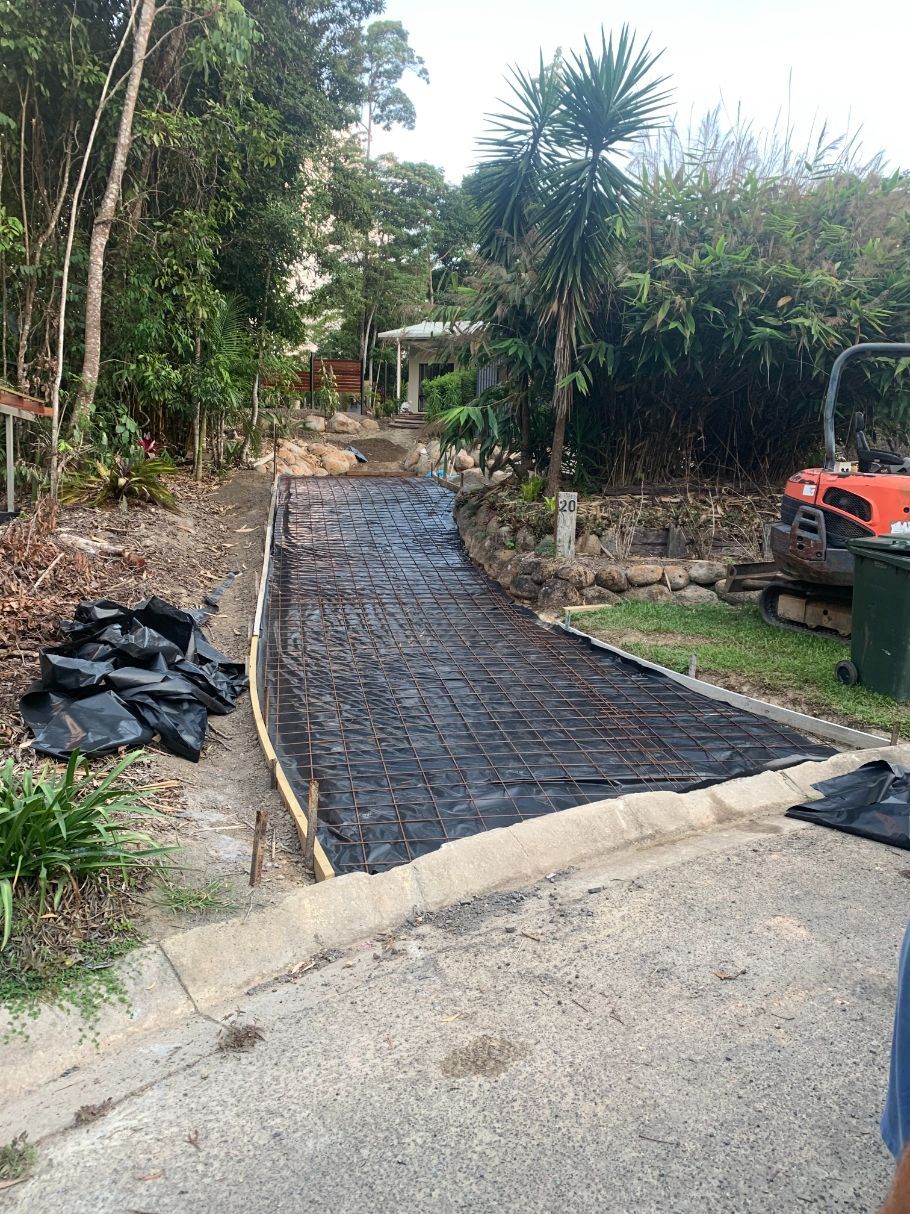 A Man Is Pouring Concrete Into a Concrete Slab on A Construction Site — Bunker FNQ in Cairns, QLD 