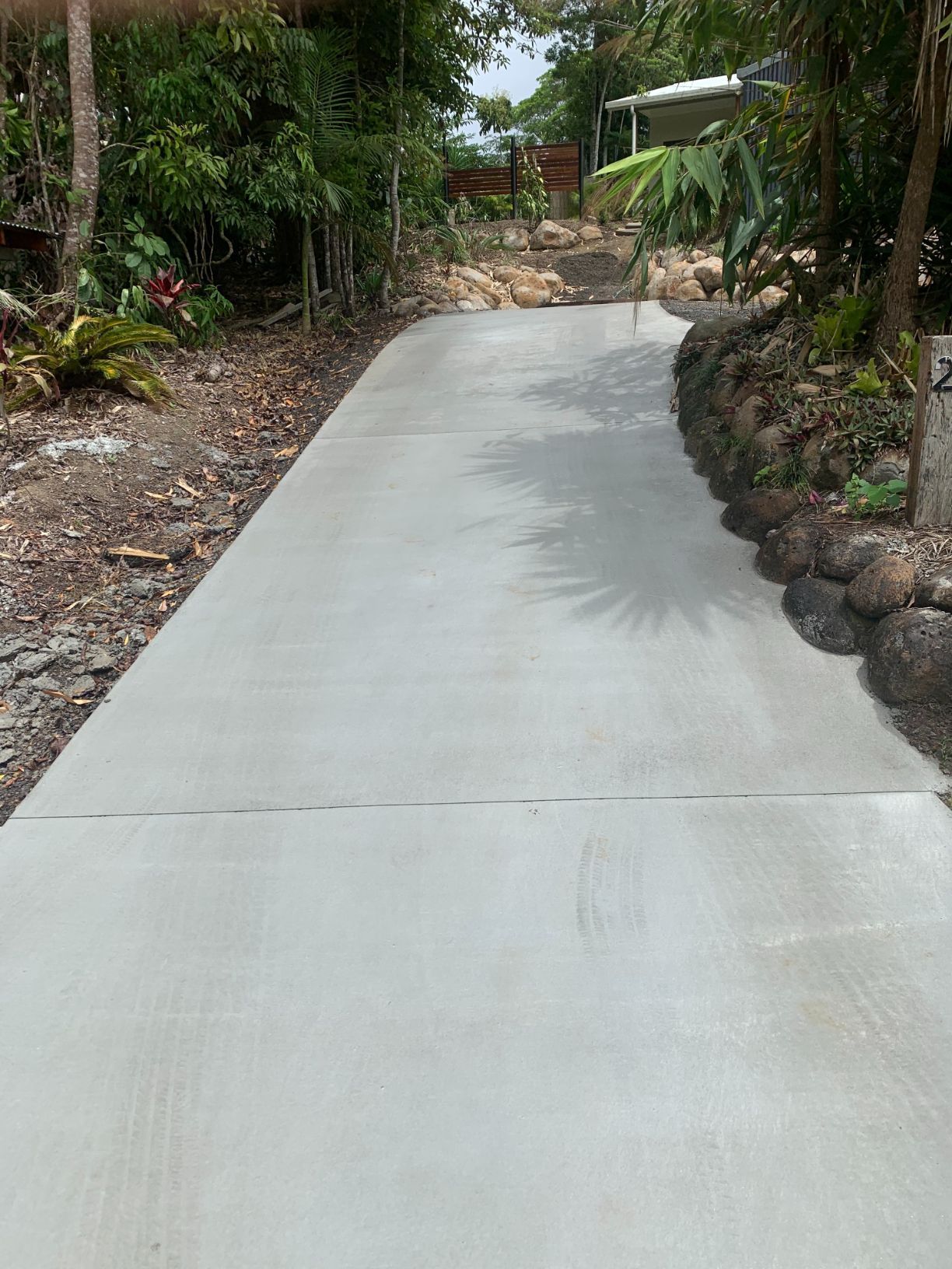 A Construction Worker Wearing a Hard Hat Is Standing in Front of A Wheelbarrow Filled with Concrete — Bunker FNQ in Kuranda, QLD
