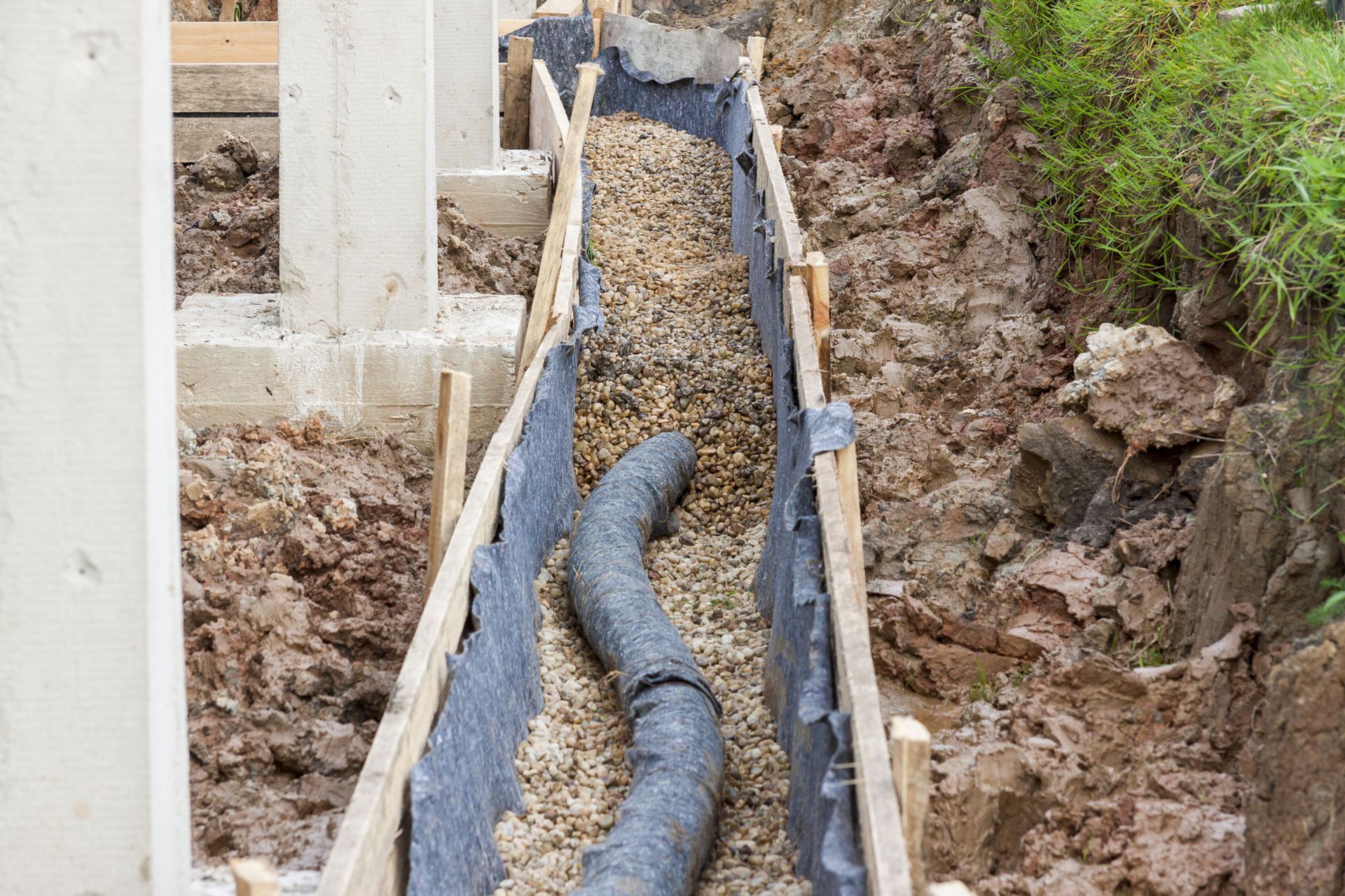 A drain pipe is being installed in a trench.