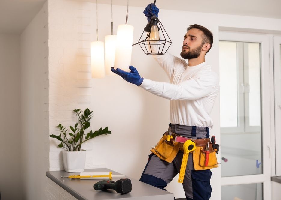 An Electrician is Working on installing lights in a house — SEP Electrical Pty Ltd in Towradgi, NSW