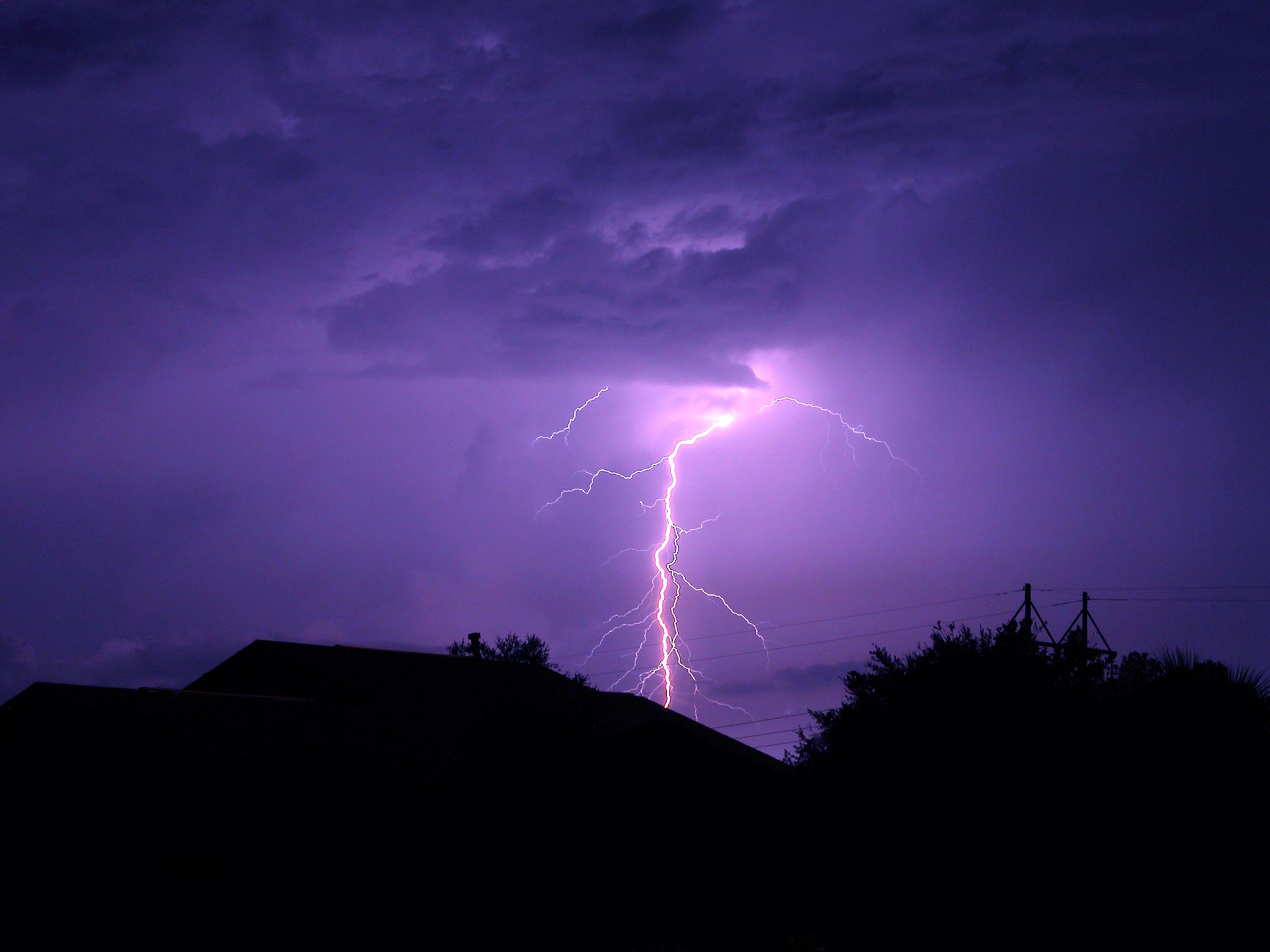 A lightning bolt is visible in the night sky