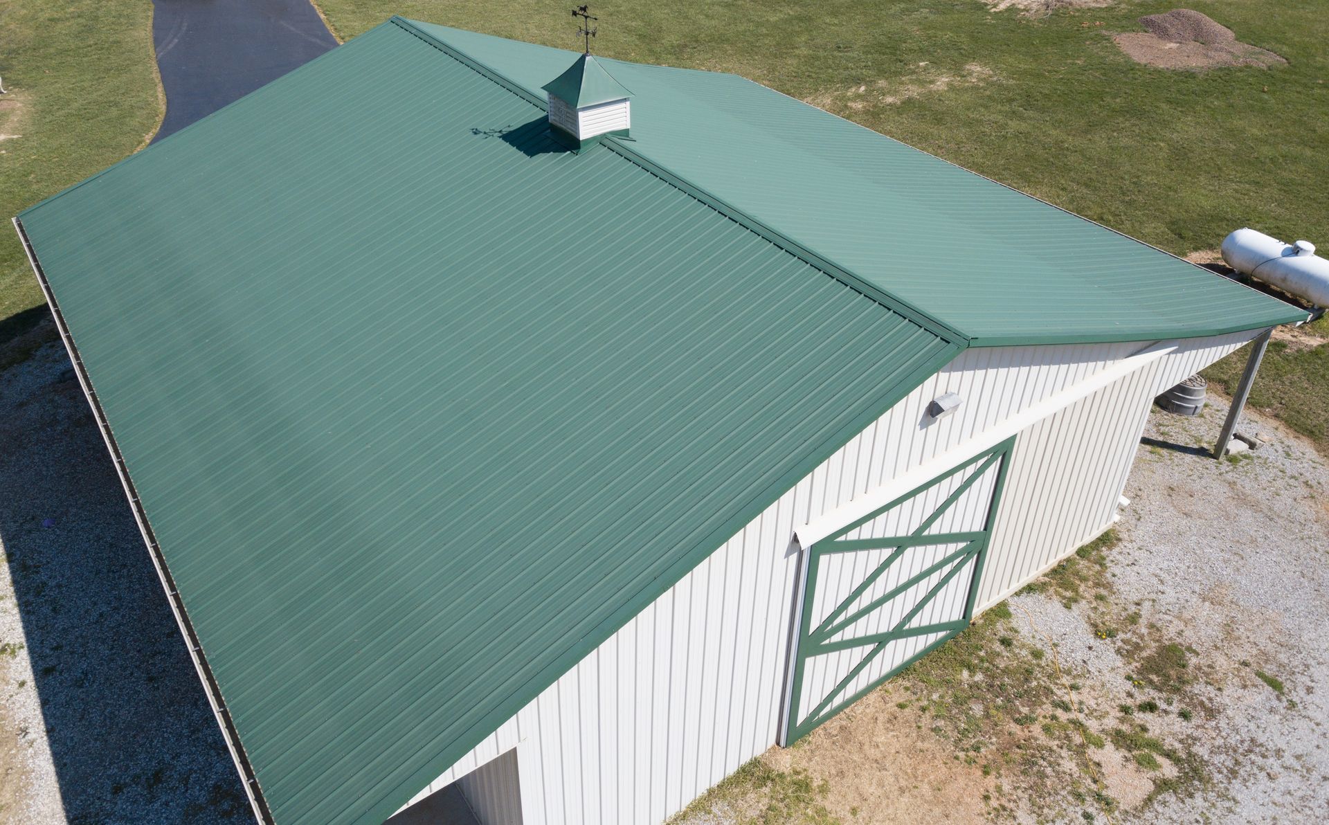 A man is standing on top of a roof holding a clipboard and giving a thumbs up.