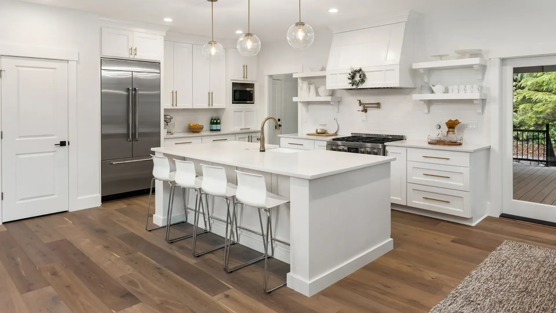 A kitchen with white cabinets and stainless steel appliances and a large island.