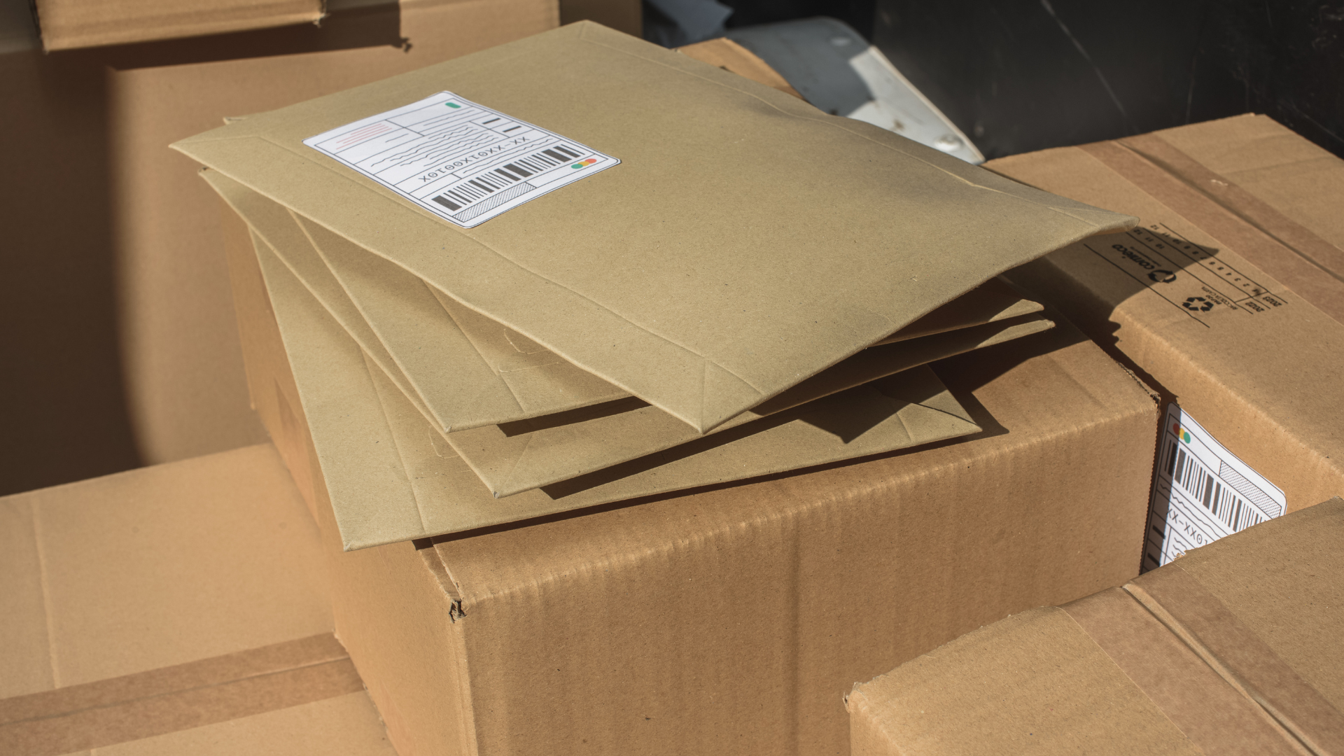 A stack of brown envelopes sitting on top of a cardboard box.