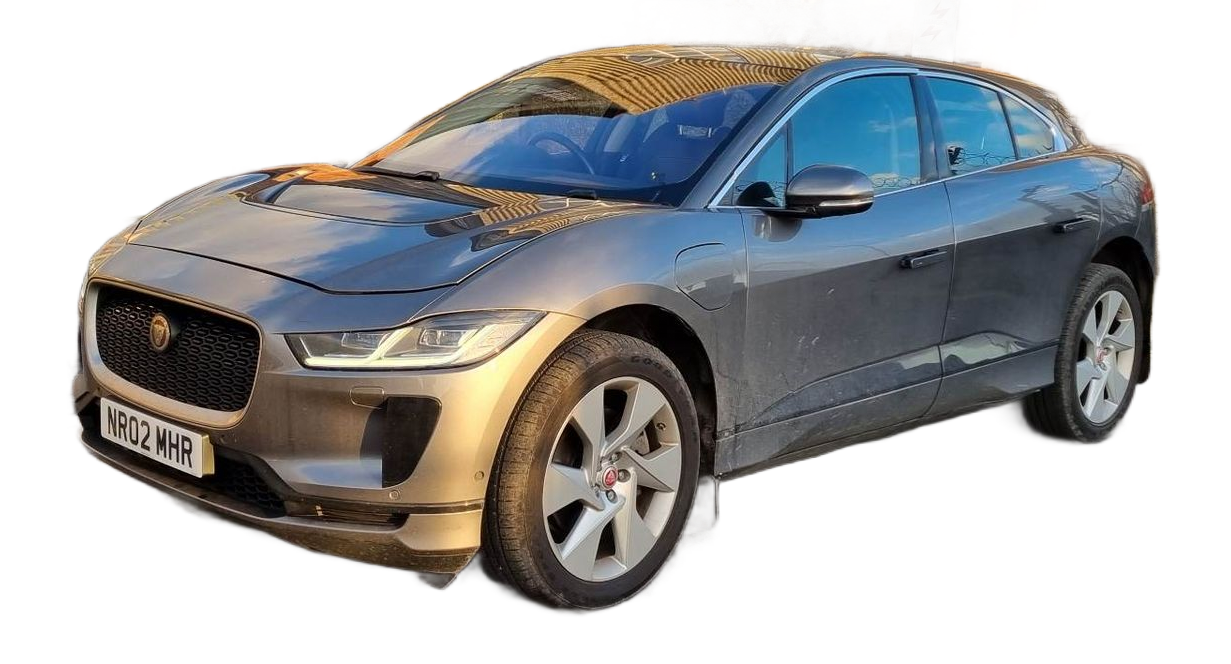 Green Land Rover Defender parked in a desert landscape. A person stands on the roof, overlooking the scenery.