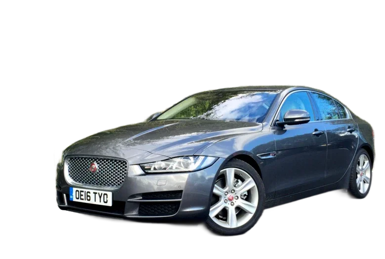 Green Land Rover Defender parked in a desert landscape. A person stands on the roof, overlooking the scenery.