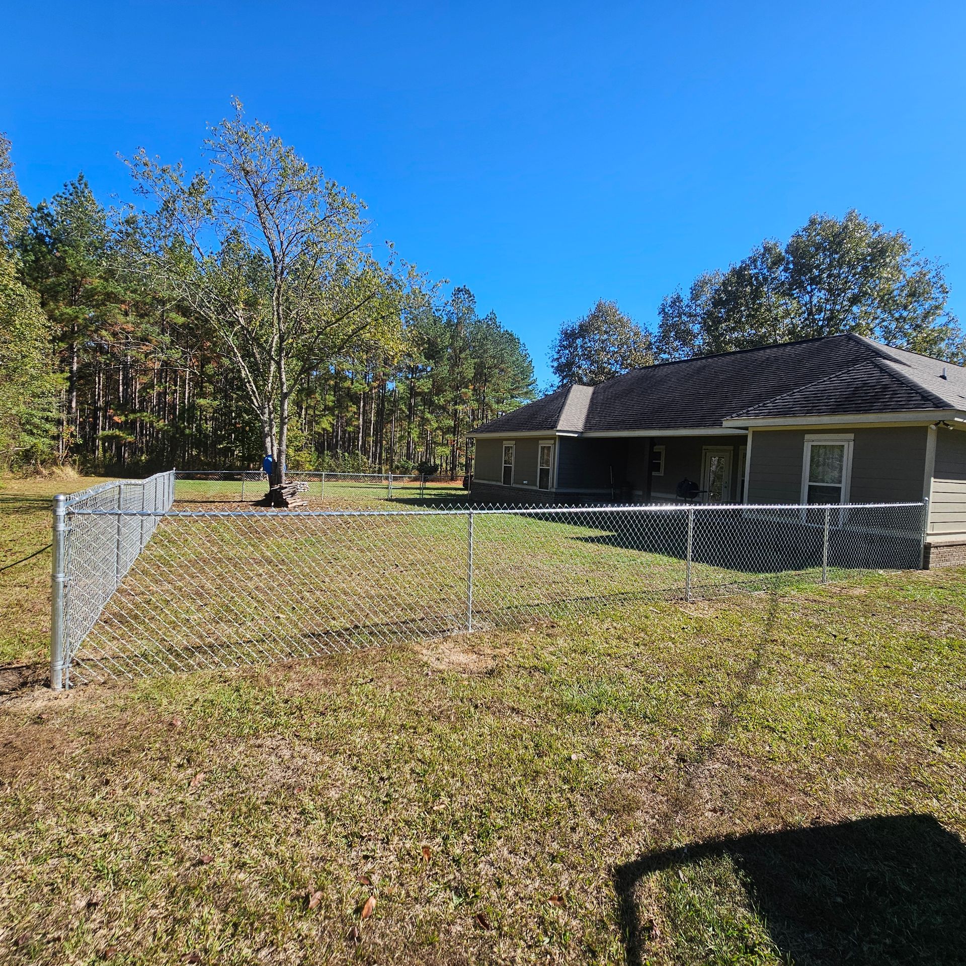 A house with a chain link fence in front of it.