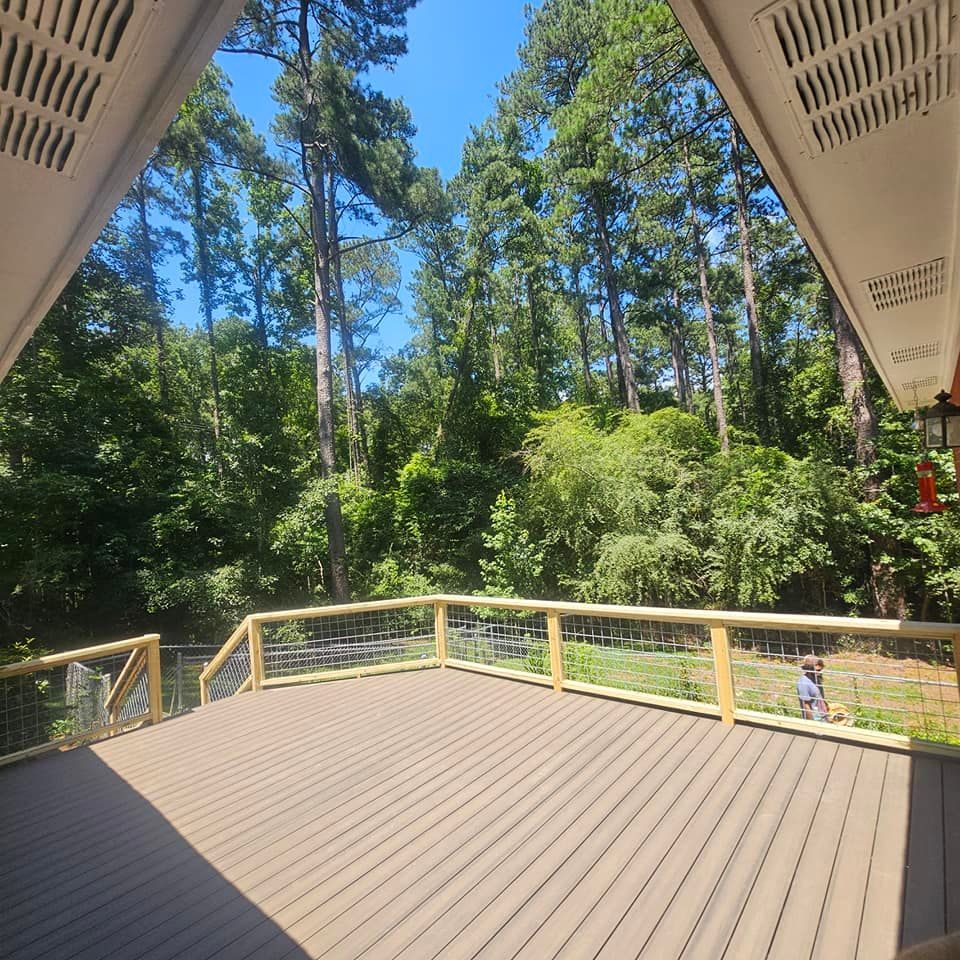 A deck with a fence and trees in the background