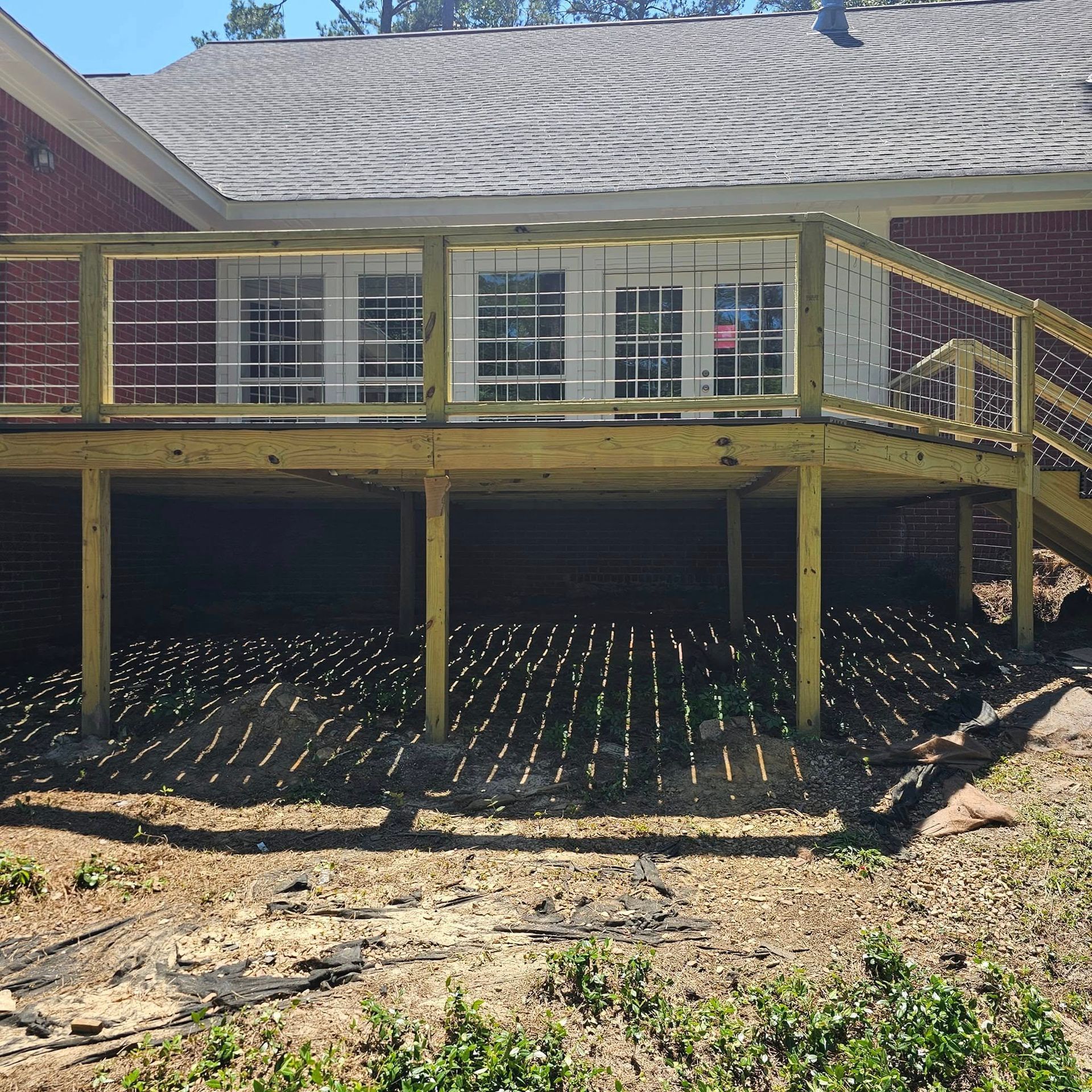 A brick house with a wooden deck and stairs