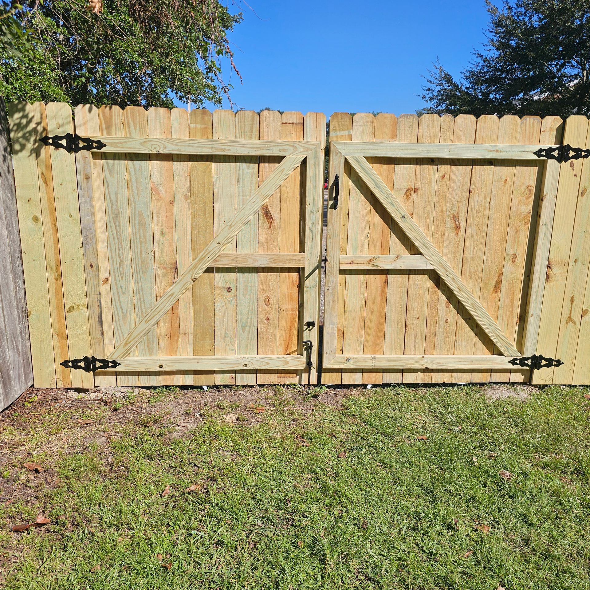 A wooden fence with a gate in the backyard.