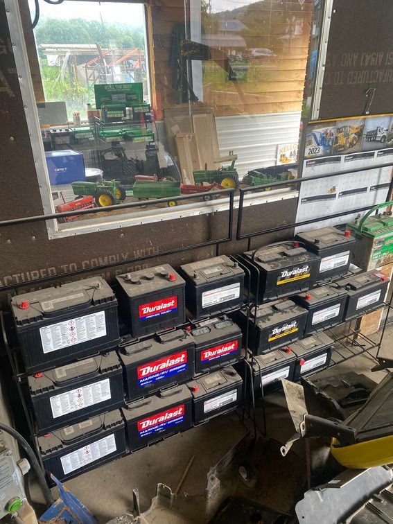 A bunch of batteries are stacked on top of each other in a garage.