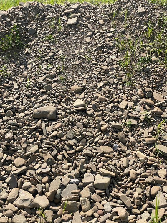 A pile of rocks sitting on top of a grassy field.