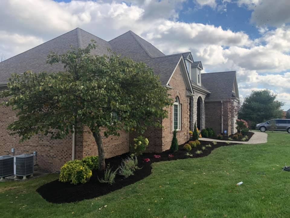 A large brick house with a lush green lawn in front of it.